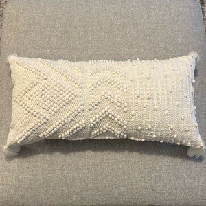 White rectangle throw pillow with tassels on corners 23 inch by 11 inch